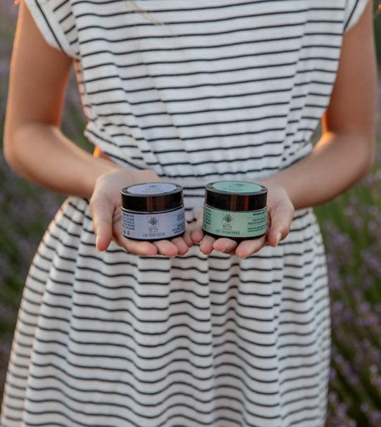 בחורה אוחזת בקרם אזוב ולבנדר טבעיים